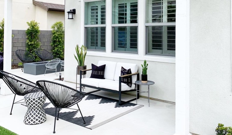 Spending a little time mulching and weeding can provide you with an outside oasis. Backyard with plantation window treatments