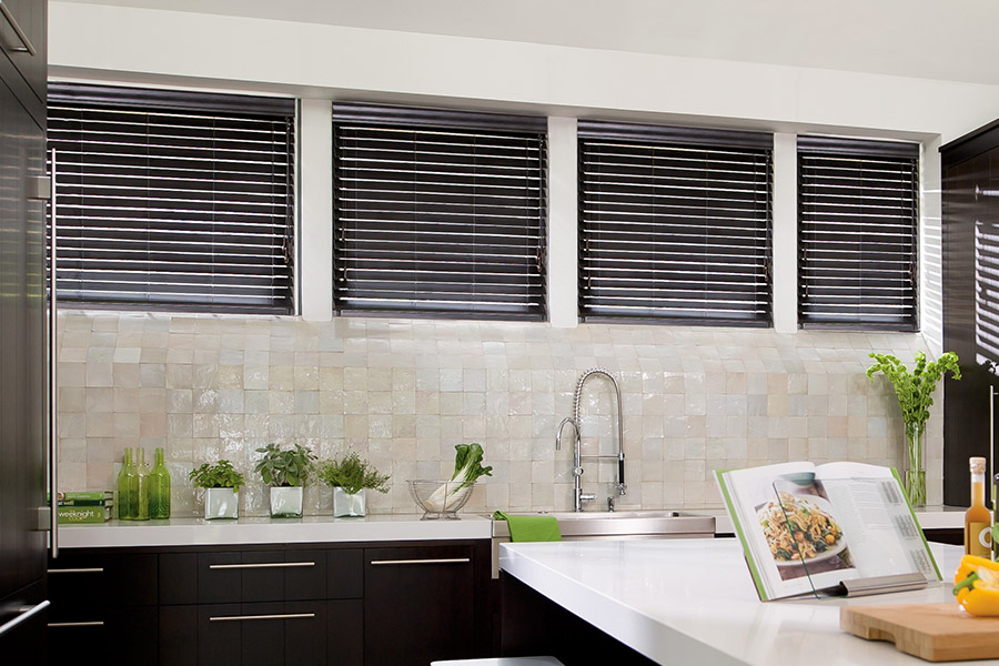 Choose custom Polywood faux wood blinds for your kitchen in Tampa. Special shaped faux wood blinds in several windows above a sink.