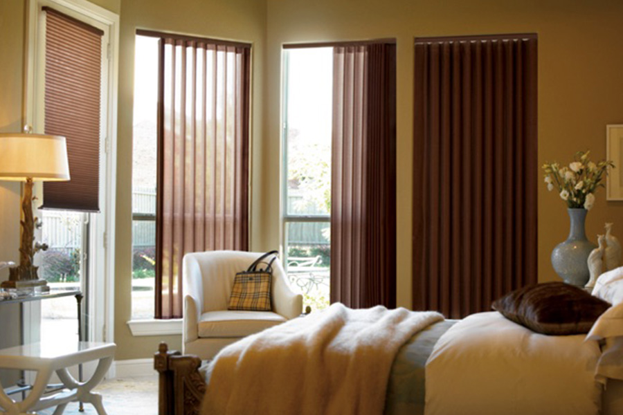Choose durable and high-quality fabric or vinyl vertical blinds in Tampa. Maroon fabric vertical blinds inside a bedroom