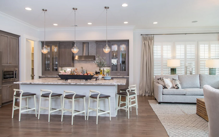 Illuminate your home with custom interior shutters in Tampa. White arched shutters in a white kitchen with lots of light.