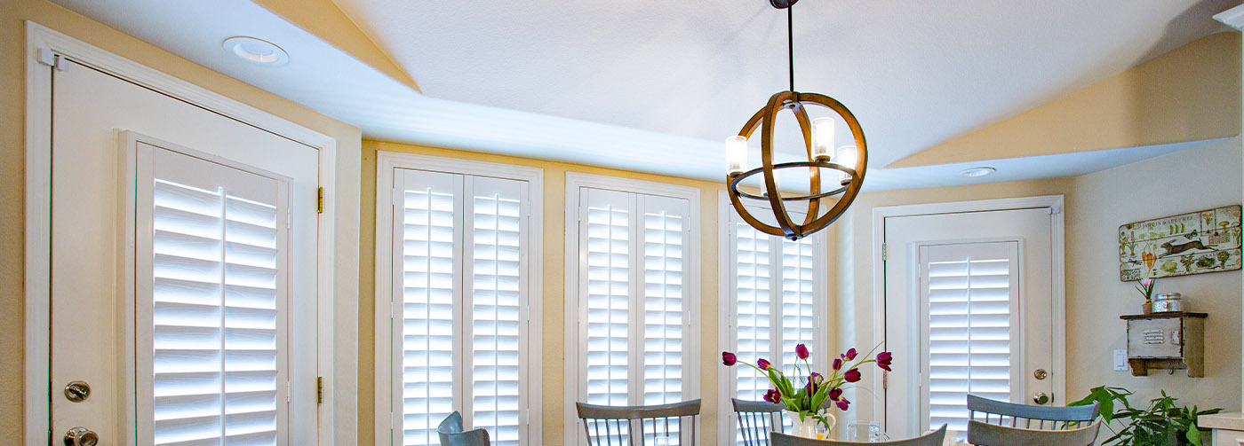 French doors and large white Polywood shutter windows in a breakfast nook area.