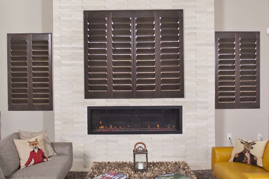 Available in a range of wood stains and paints, hardwood interior window shutters can be customized for any space. Wood shutters on living room windows