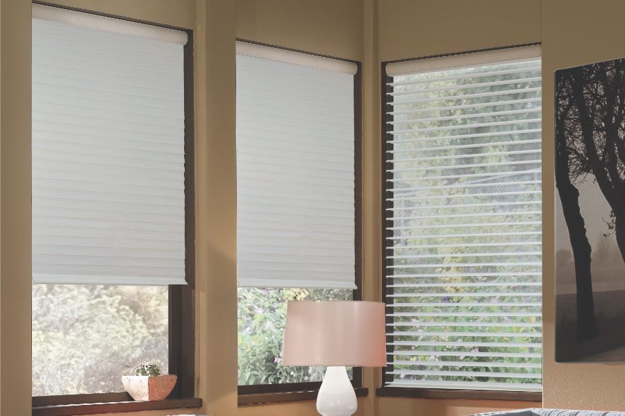 Opaque motorized window shades in Tampa keep hot UV rays out of your home. Gray motorized sheer shades on corner windows next to gray furniture