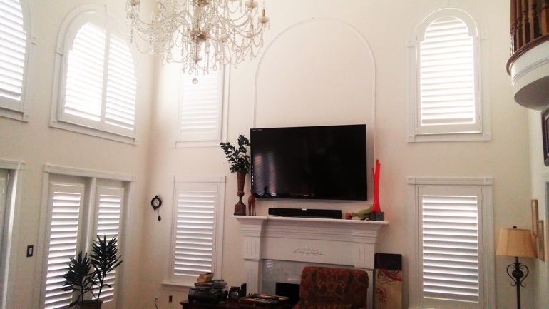 Tampa great room with wall-mounted TV and arched windows.