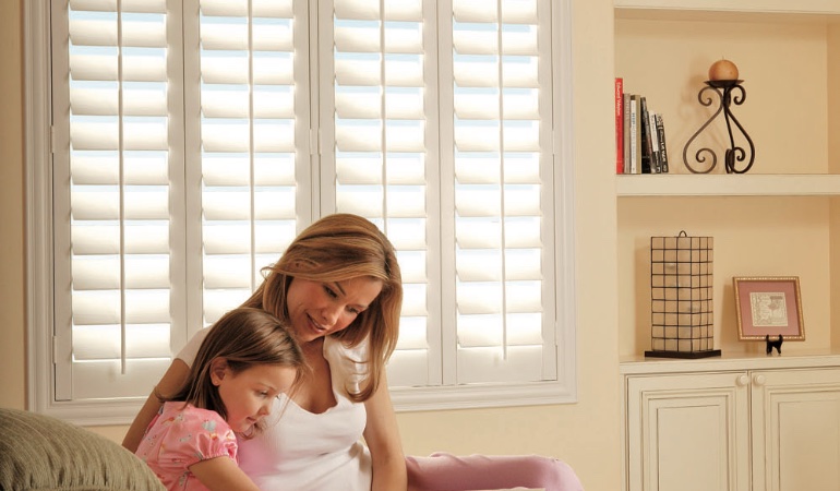 Easy to clean Polywood shutters are ideal cord-free options for kids. Mom and daughter in front of window